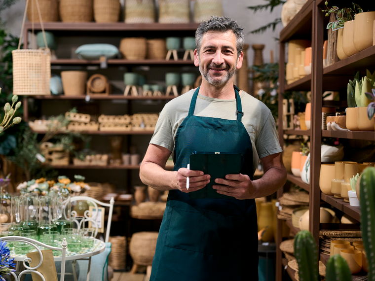 The owner of an independent homeware shop behind the counter